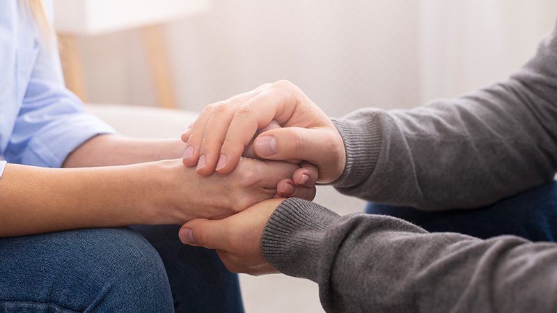 A person wrapping their hands over another persons